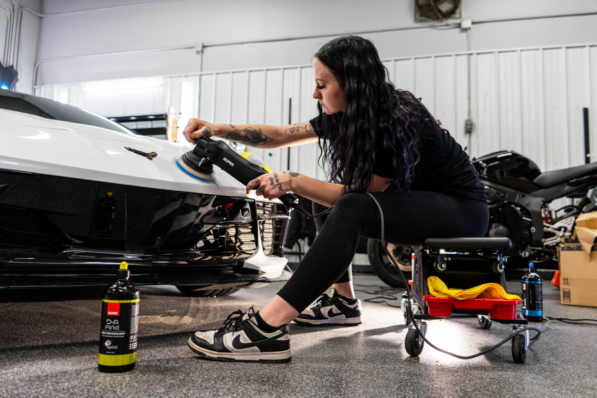 Girl applying ceramic coating to a corvette