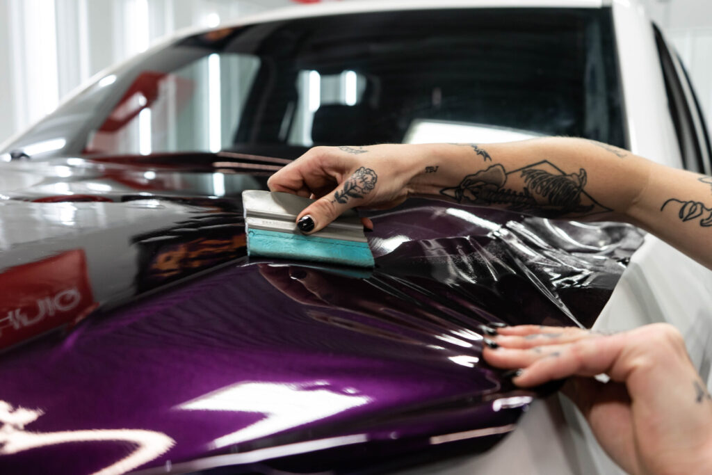 Applying purple vinyl wrap on a car in Minnesota